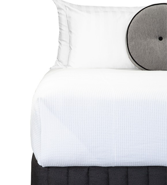 Bed Dressed with Carlo Blanket (White), Suite Valance (Siam Charcoal), Claridge Round Cushion (Genoa Seal Grey), Majestic King & Microball Resort Pillows with Hampton White Stripe Pillowcases